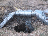 ため池に開いた穴の周りに、土嚢を積んで土手を作る